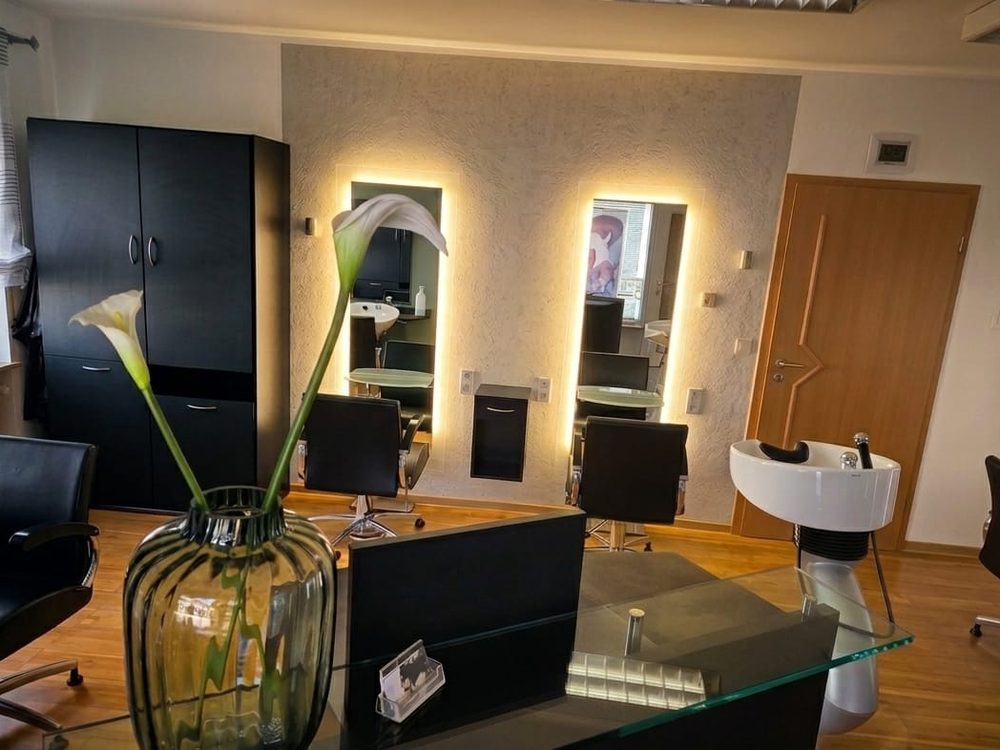 Frisierplätze mit beleuchteten Spiegeln im Friseursalon Häfner