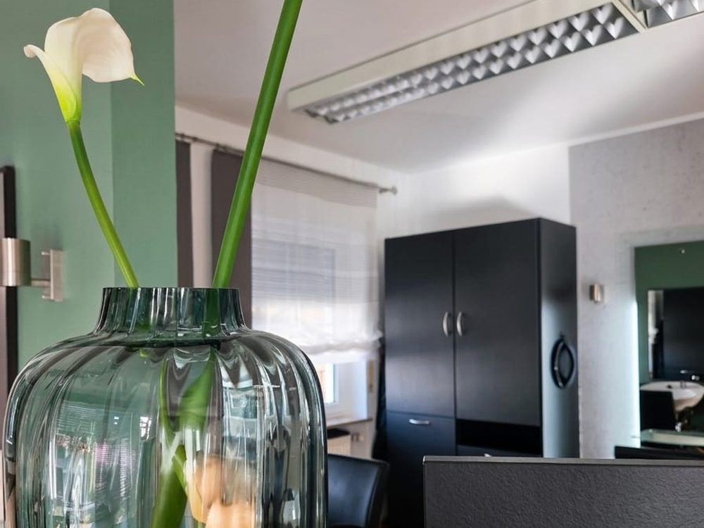 Empfangsbereich mit Blumendekoration im Friseursalon Häfner